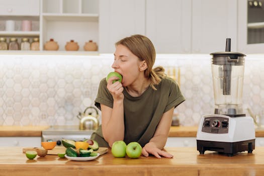 Blender with fruits and vegetables on the countertop